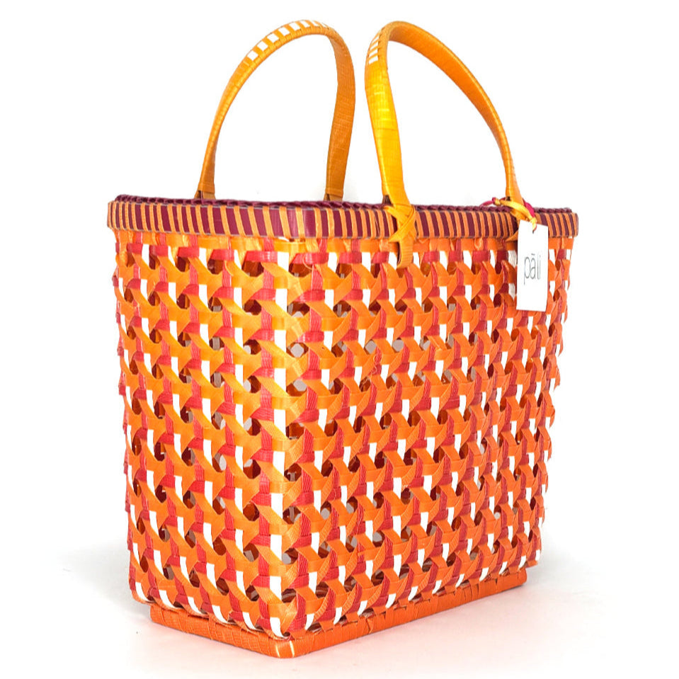 Orange woven plastic basket with yellow handles on a white background